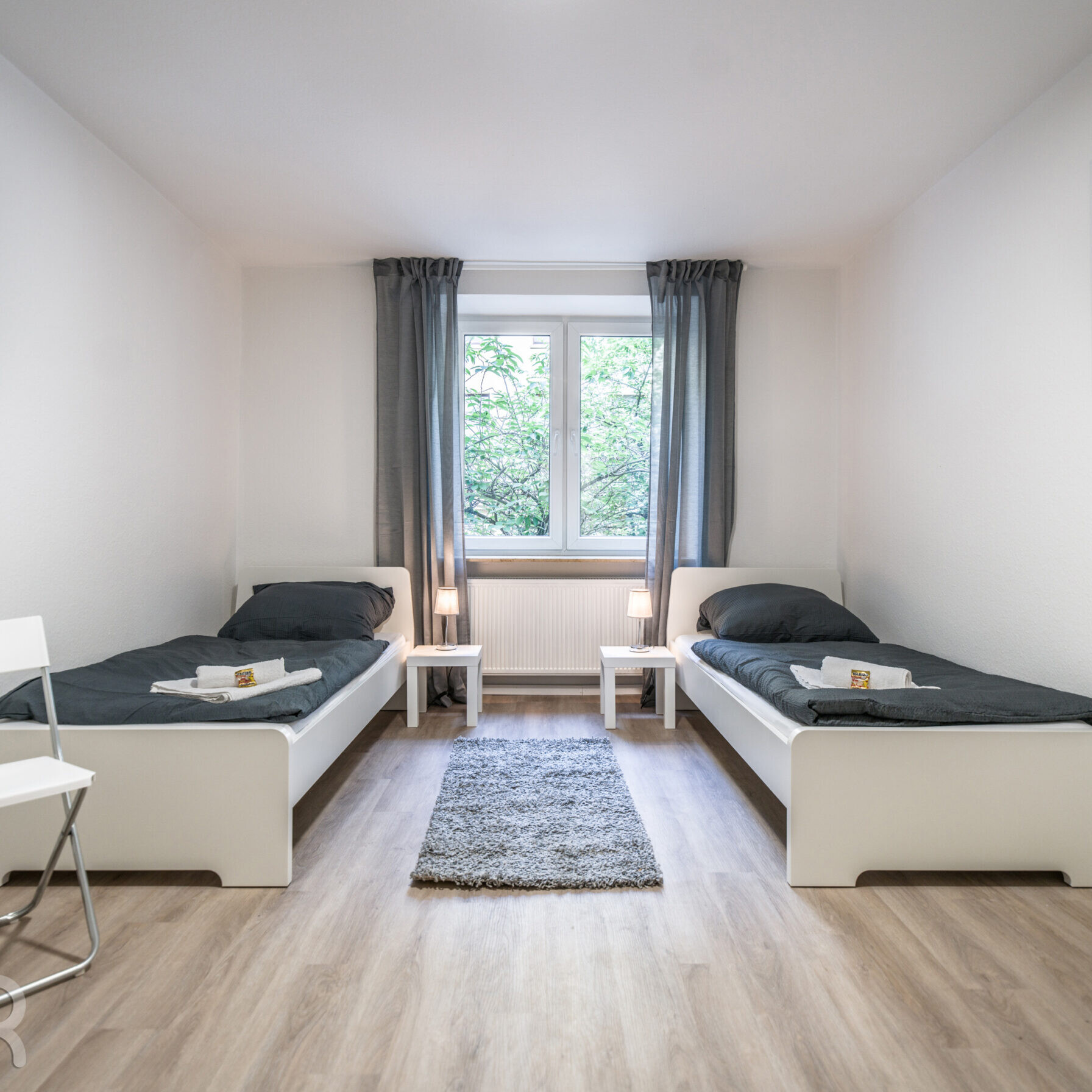 Monteurwohnungen Frankfurt – voll ausgestattetes Schlafzimmer mit zwei Einzelbetten, stilvollem Design und Tageslicht